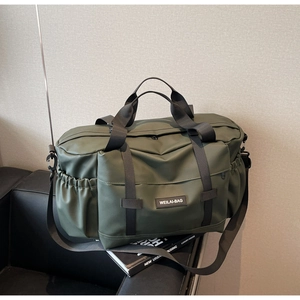 Sac de voyage vert olive sur canapé noir montrant la texture mate imperméable et détails