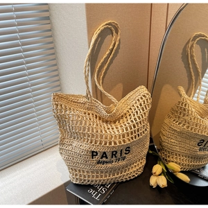 Detalle del bolso tote de paja tejida calada con estampado negro Paris 1970