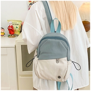 Close-up of color-block mini backpack with gray-blue and cream white nylon details
