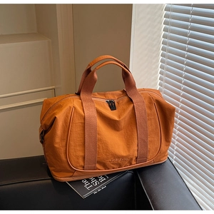 Détail du sac de voyage orange en nylon imperméable avec compartiment à chaussures
