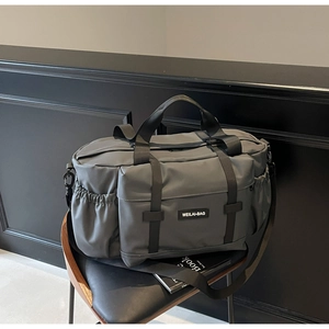 Détail du sac de voyage gris foncé avec poche frontale et bandoulière réglable