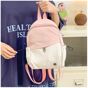 Détail du mini sac à dos en nylon rose et beige avec poches latérales à cordon