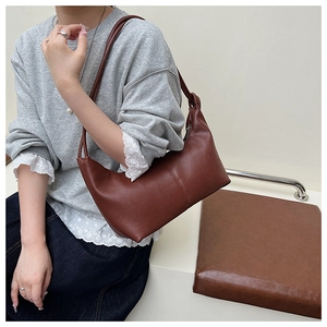 Detail view of a brown leather hobo bag showing soft texture and vertical seam design