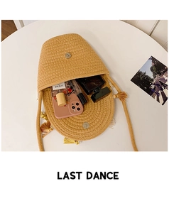 Detailed view of woven straw bucket bag interior with magnetic closure and fringe