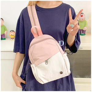 Détail du sac bandoulière en nylon imperméable rose et beige avec design contrasté