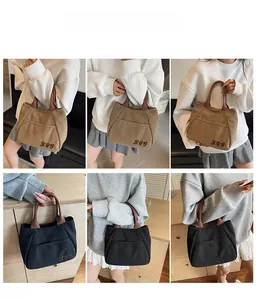 Detailed views of embroidered canvas tote bags in khaki and black with front pockets