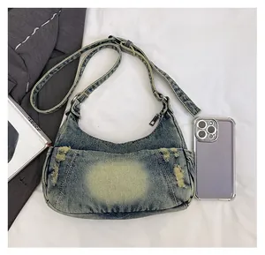 Macro shot of denim hobo bag with phone inside showing large storage capacity