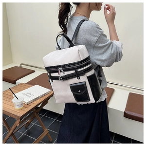 Detail of minimalist black and white contrast backpack with leather straps and metal zippers
