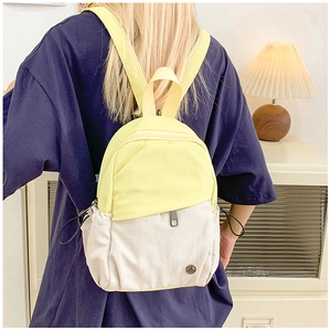 Detail of a mini yellow and beige waterproof nylon backpack with drawstring side pockets