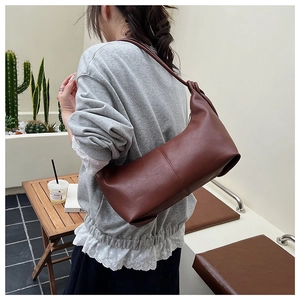 Close-up of a vintage brown leather shoulder bag with knotted strap and stitching details