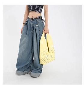 Détail du sac cabas en cuir verni jaune avec rivets et style denim vintage