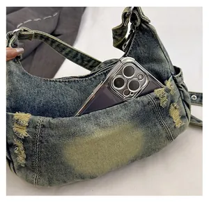 Detail of vintage washed denim tote bag showing functional front pocket and frayed edges