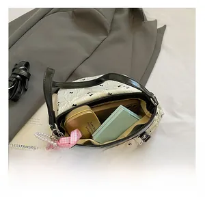Detail view of white shoulder bag interior showing capacity for cosmetics and phone
