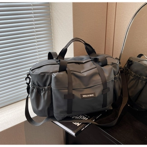 Détails du tissu en nylon gris foncé et des poches utilitaires du sac de sport voyage