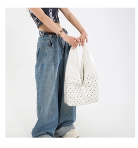 Vue détaillée du sac hobo en cuir verni blanc avec rivets argentés et finition brillante