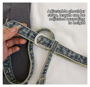 Close-up of adjustable blue denim strap with silver metal eyelets and buckle detail