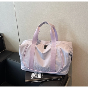Détail du sac de voyage en nylon lilas avec poignées robustes et structure spacieuse