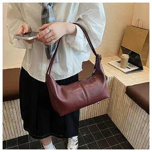 Detail of burgundy half-moon shoulder bag with knot strap and elegant central stitching