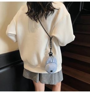 Detailed view of mini hat coin purse in light blue canvas with double zipper and woven strap