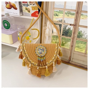 Close-up of bohemian woven straw bag with colorful tassels and embroidered beadwork