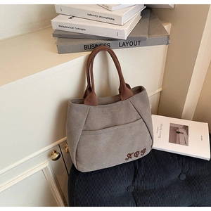 Detailed close-up of heavy-duty canvas tote bag with contrast handles and embroidery