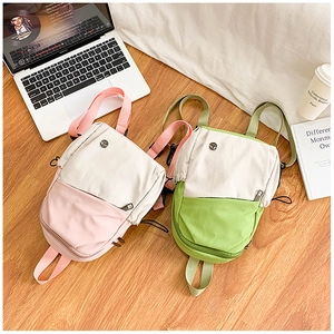 Détail de mini sacs à dos en toile bicolore avec poches latérales et fermeture éclair