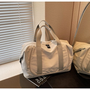 Détail du sac de voyage en nylon beige imperméable avec marquage en relief