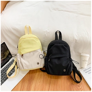 Détail du petit sac à dos en nylon imperméable avec design bicolore et coutures