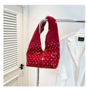 Vue détaillée du sac à bandoulière en cuir verni rouge avec rivets argentés