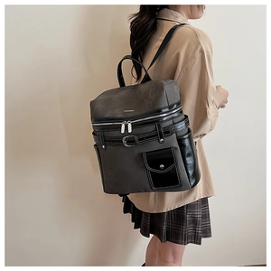Detailed side view of a grey and black multi-pocket backpack worn by a model