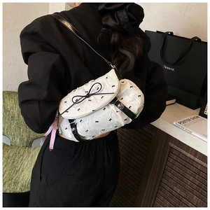 Detail of white pleated crossbody bag with black bows and checkered ribbon trim