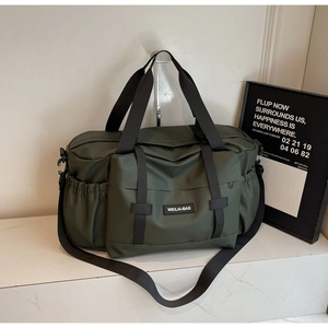 Gros plan du sac de voyage étanche vert olive montrant la texture et la poche latérale à cordon