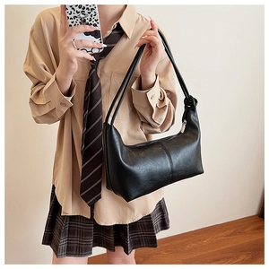 Close-up of black PU leather dumpling bag with stylish knotted strap detail