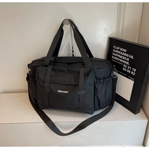 Détail du sac de voyage avec poignées en nylon durable et bandoulière réglable pratique