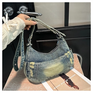 Detailed view of the vintage washed denim hobo bag featuring distressed ripped fabric