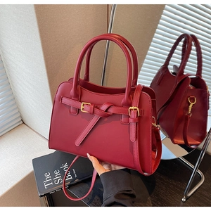 Detailed view of dark red bridal handbag with gold hardware and elegant belt buckle