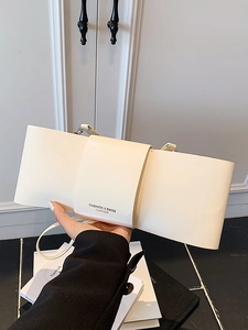 Minimalist cream white leather underarm bag with unique wrap design and thin strap