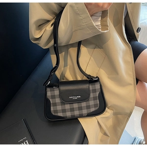 Détail du sac sous le bras à carreaux vintage avec bordure en cuir sur le mannequin