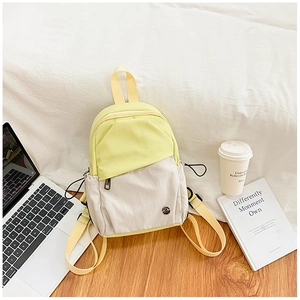Detail of a minimalist yellow and beige nylon mini backpack in a cozy lifestyle setting