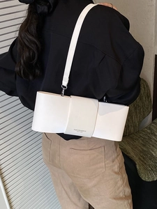 Chic cream bow-shaped shoulder bag in matte leather shown from a stylish side angle