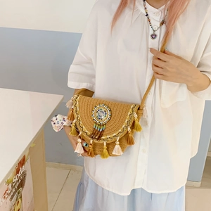 Detail of bohemian straw crossbody bag with colorful beads and tassel embellishments