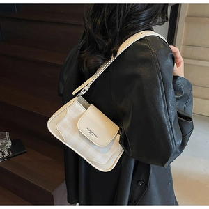 Détail du sac bandoulière à carreaux crème avec bandoulière réglable et lettrage