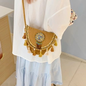 Detailed shot of ethnic woven bucket bag with beaded embroidery and colorful tassels