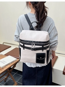 Minimalist cream and black contrast backpack with adjustable straps and front pocket