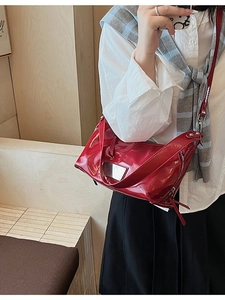 Red glossy patent leather crossbody tote bag with wide strap and side zippers