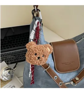 Detailansicht eines Plüschbär-Anhängers mit Webseilen an einem modischen Rucksack