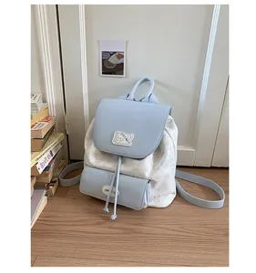 Détail du sac à dos bleu clair contrasté avec imprimés de chats et fermeture par cordon