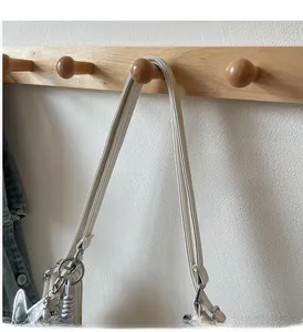 Détail du sac à main blanc cassé avec poignée ronde, breloque cœur et ferrures en métal