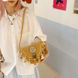 Detail of bohemian woven straw bag featuring colorful tassels and mandala bead embroidery