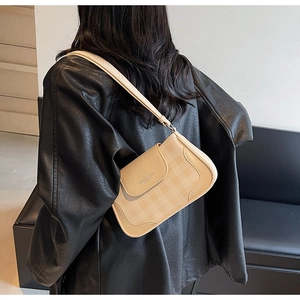 Détail du sac beige avec motif à carreaux et logo de marque élégant sur le rabat